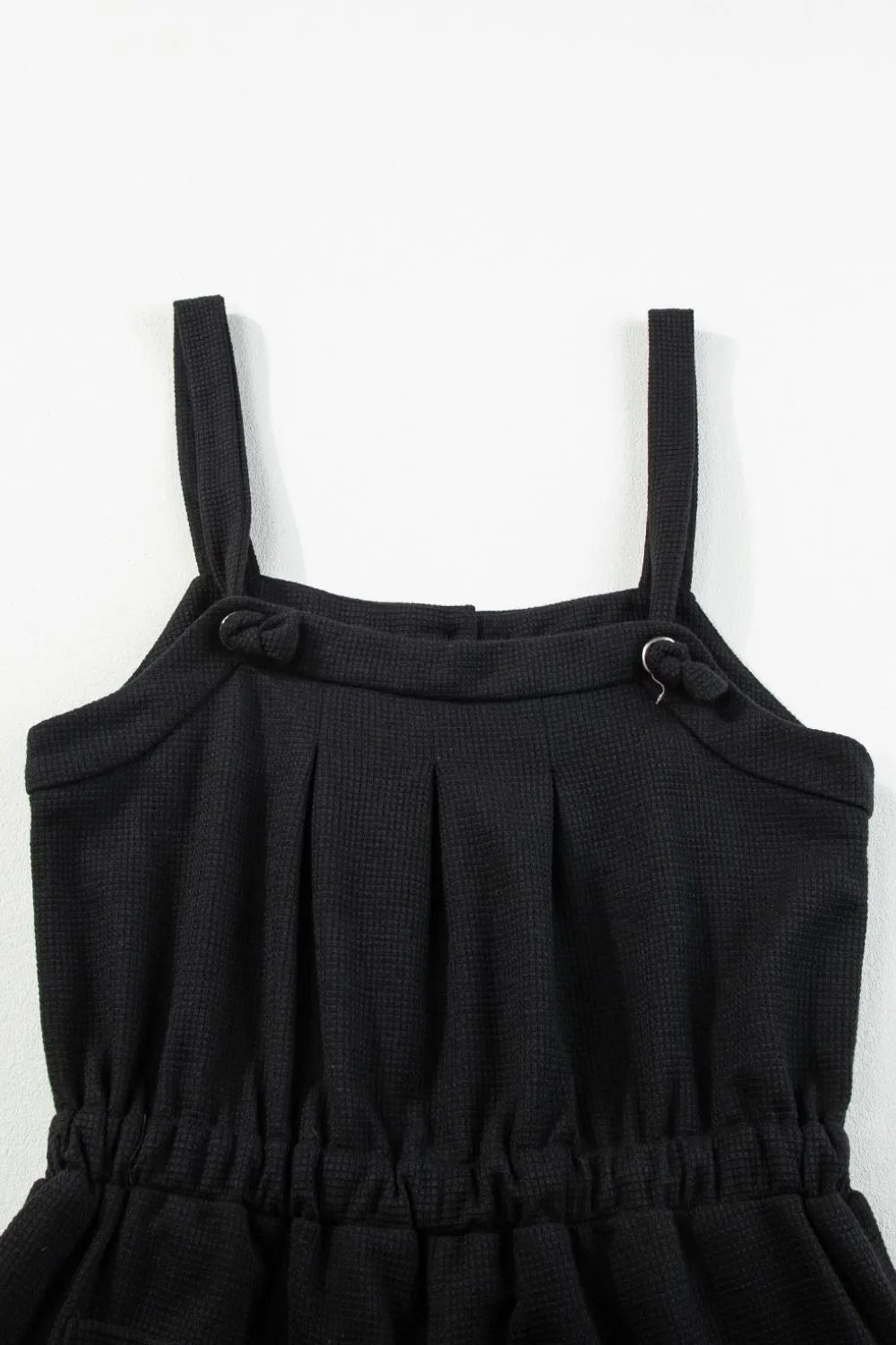 Back of black jumpsuit bodice with adjustable knotted shoulder straps
