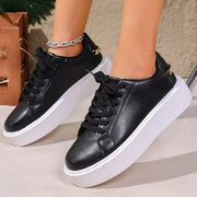 Side view of black lace-up platform sneakers with thick white soles