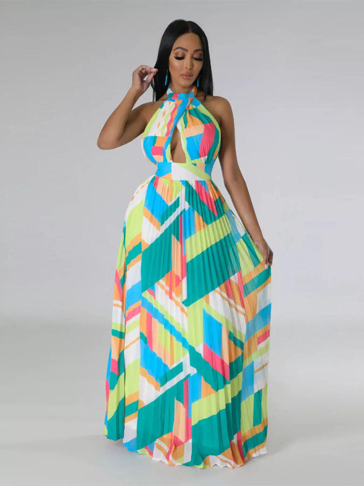 Front view of a turquoise geometric halter dress with the pleated skirt held out at both sides.