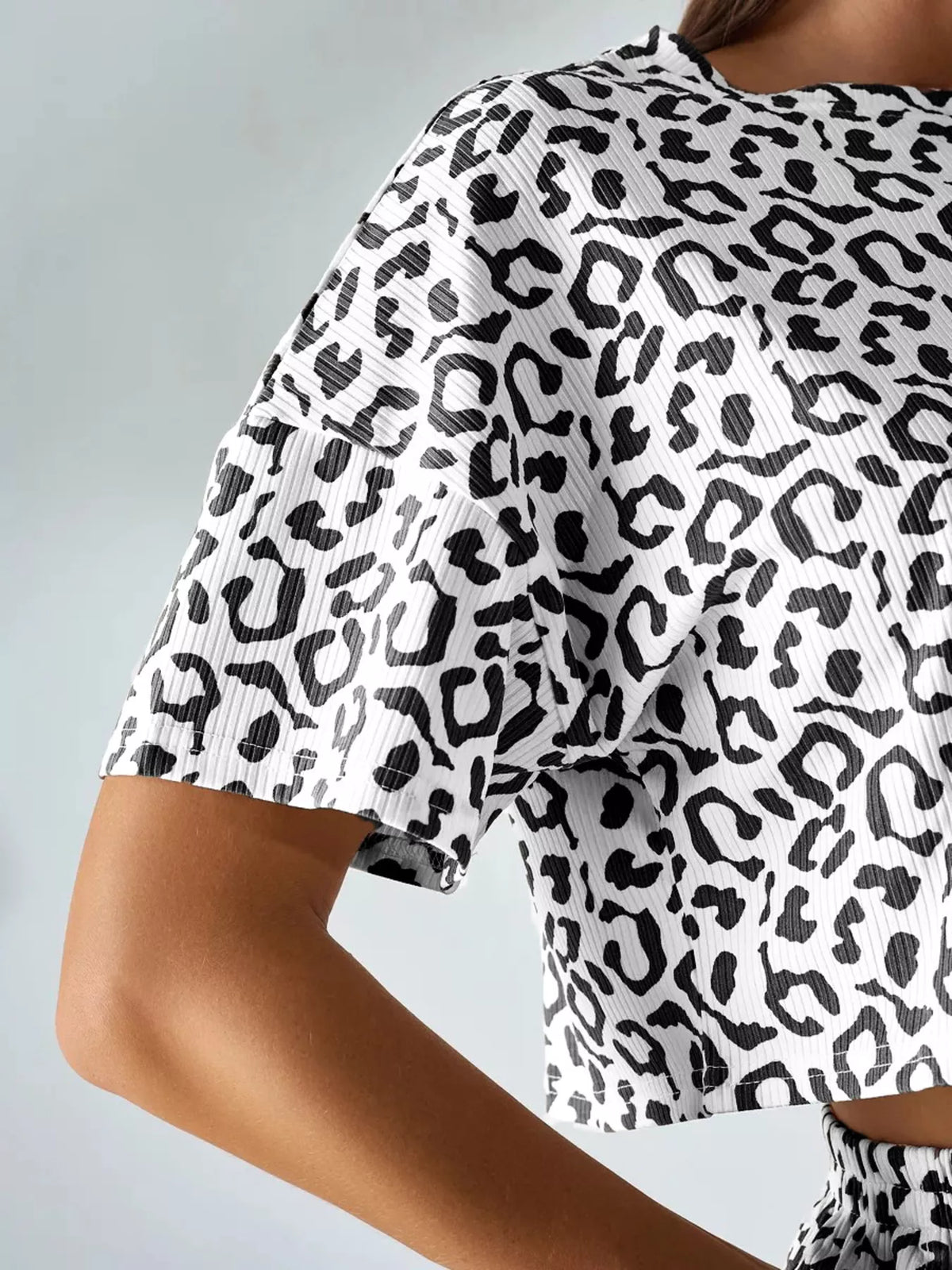 Close-up of the black leopard pattern and ribbed texture on the cropped short sleeve.