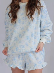 Close view of blue floral sweatshirt and matching ruffle-hem shorts