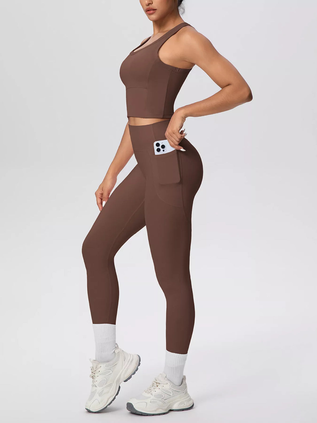 Brown tank and leggings shown from the front with one hand in pocket