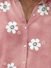 Close-up of the pink shirt's white floral print and small white buttons.