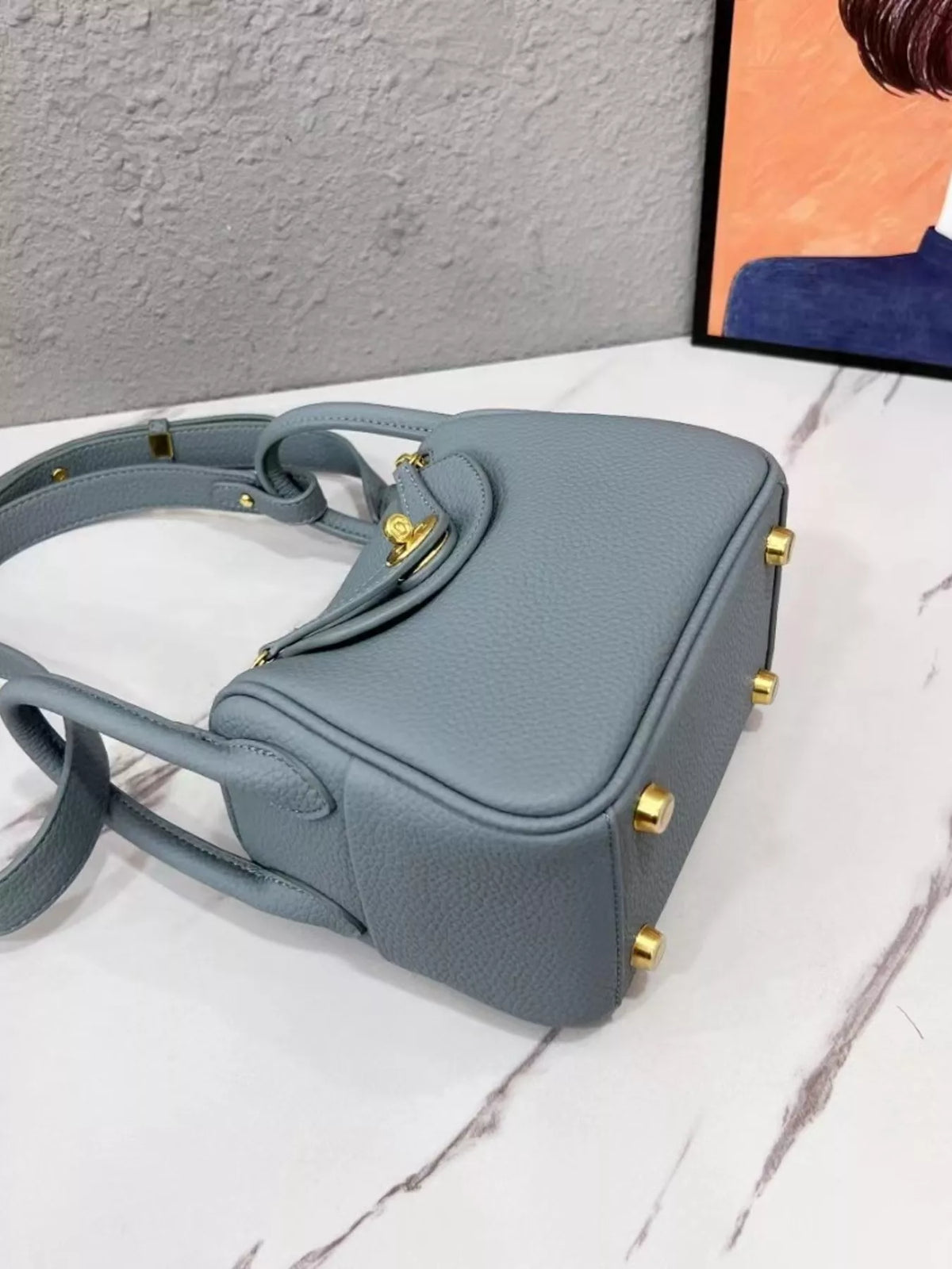 Side and base view of a blue crossbody bag