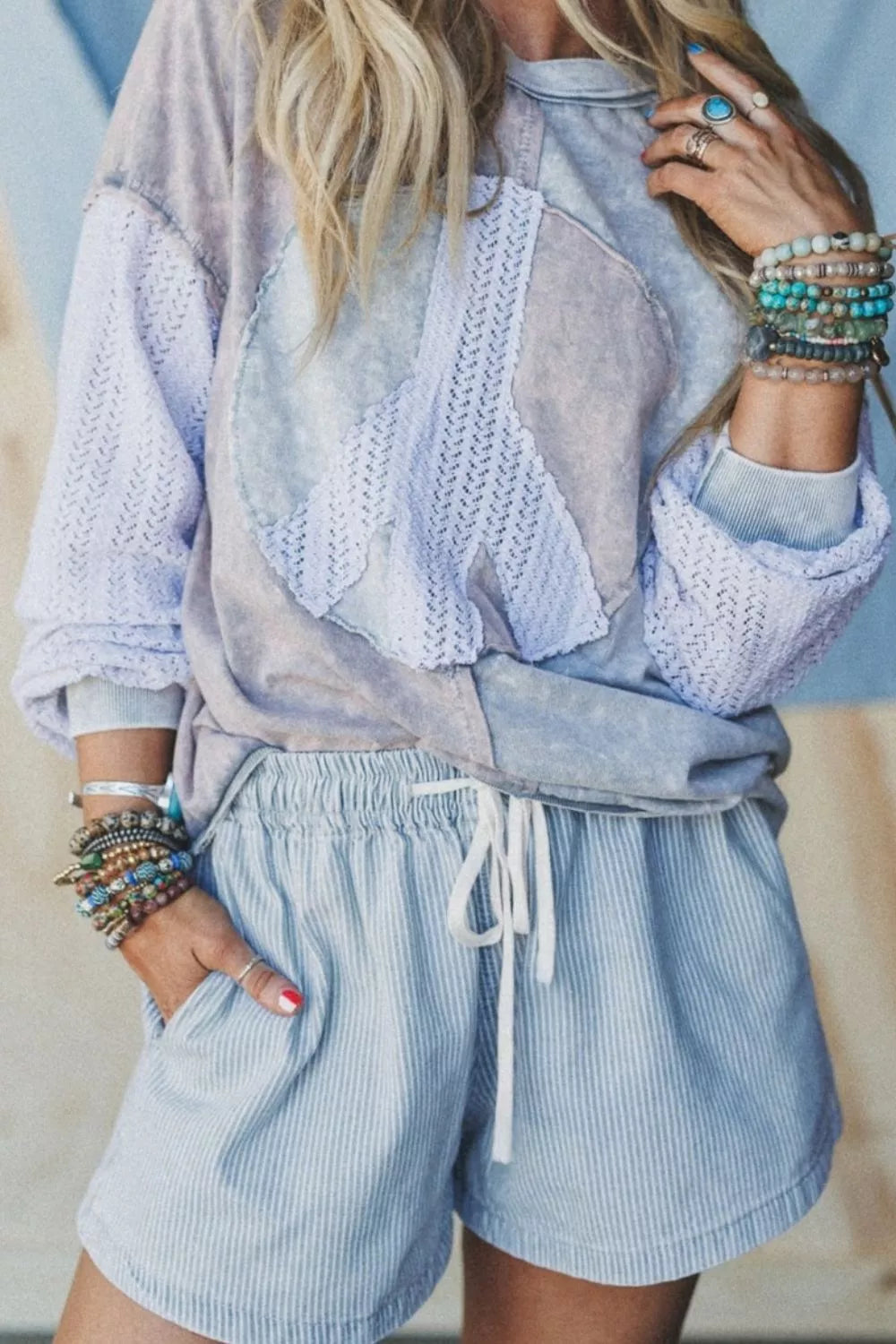 Model wearing light blue striped drawstring shorts with hands in pockets.