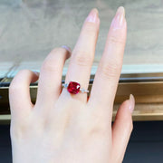 Red zircon ring worn on a hand.