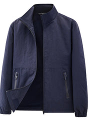 Navy stand-collar jacket with elastic cuffs and zippered pockets displayed open