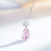 Blush-pink teardrop zircon pendant with a clear-stone accent on a silver-tone chain