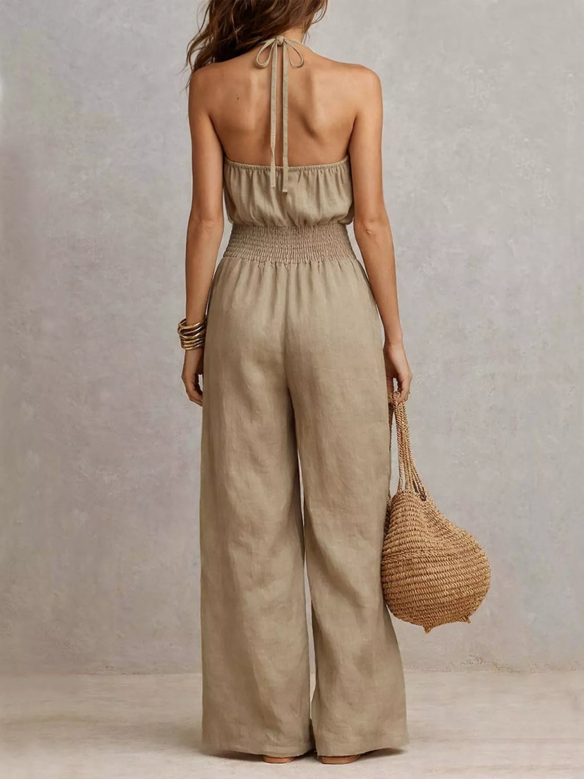 Back view of beige halter jumpsuit showing its smocked waist