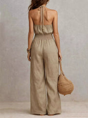Back view of beige halter jumpsuit showing its smocked waist