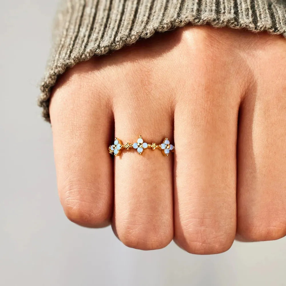 Blue-stone flower ring worn on a hand