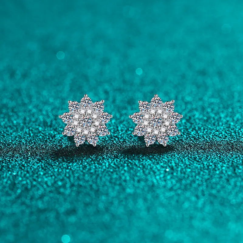 Pair of floral cluster moissanite and zircon stud earrings on teal background