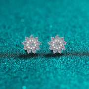 Pair of floral cluster moissanite and zircon stud earrings on teal background