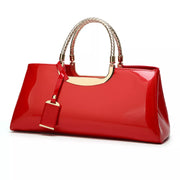 Red patent-look handbag with braided top handles and hanging tag