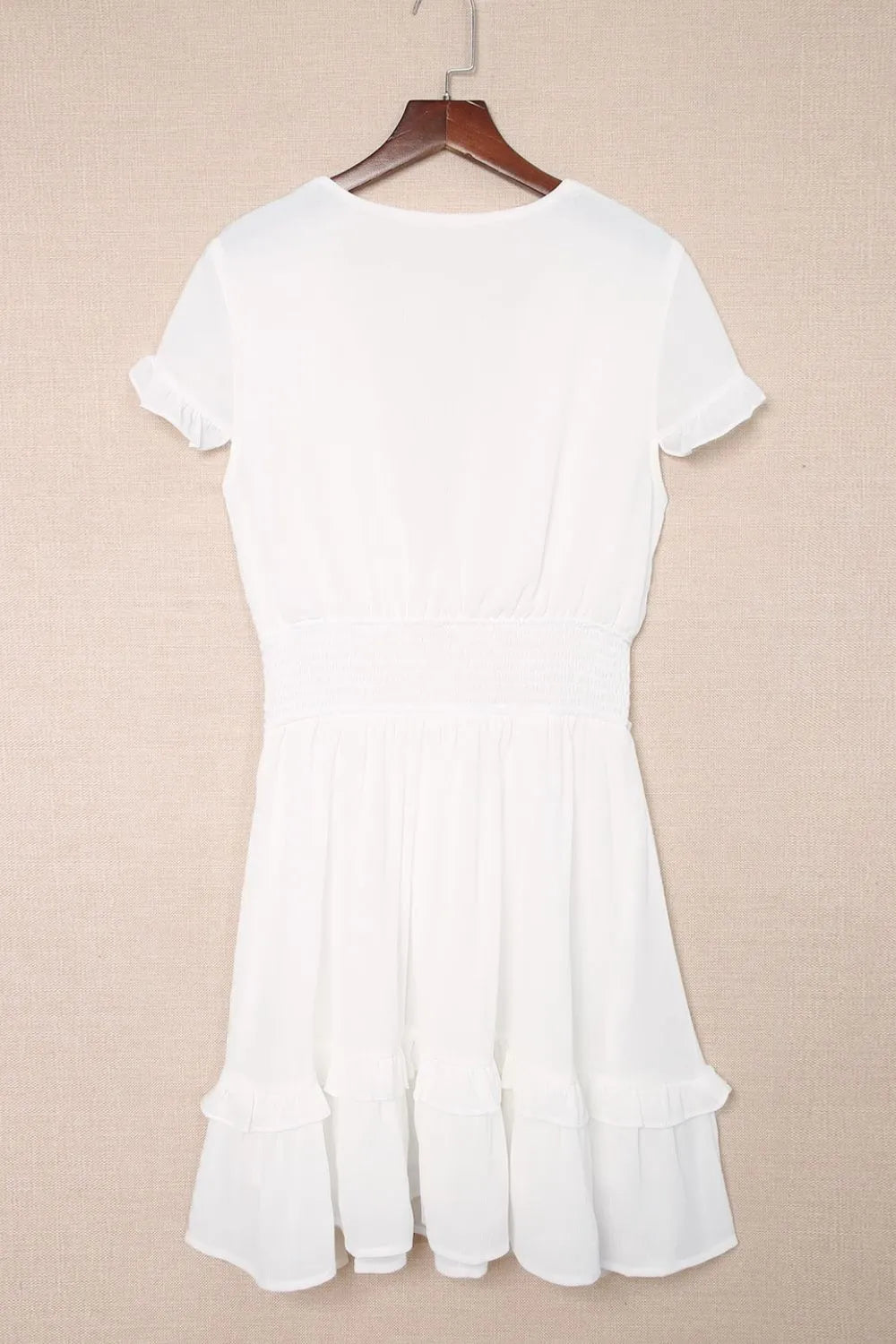 White dress displayed on hanger, back