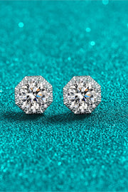 Pair of round moissanite studs displayed on teal background