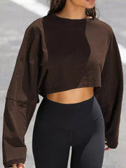 Dark brown cropped sweatshirt worn with black leggings, front view