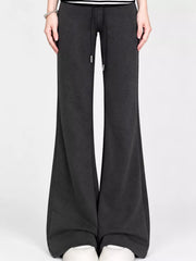 Black drawstring wide-leg flare pants worn with white shoes, front view