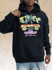 Model wearing black graphic hoodie with colorful palm tree chest print