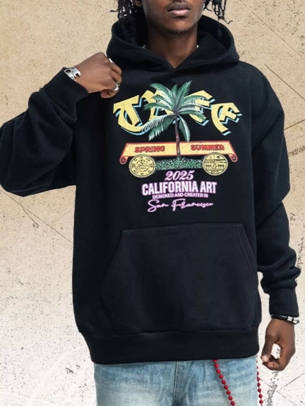 Model wearing black graphic hoodie with colorful palm tree chest print