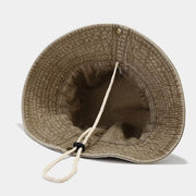 Underside of camel wide-brim bucket hat showing its chin cord and brim
