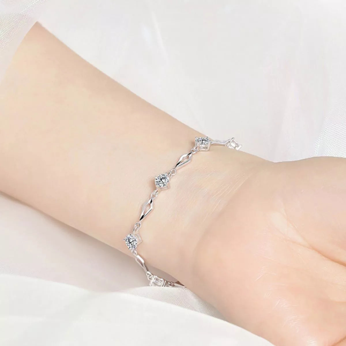 Close view of the silver-tone floral zircon bracelet worn around a wrist