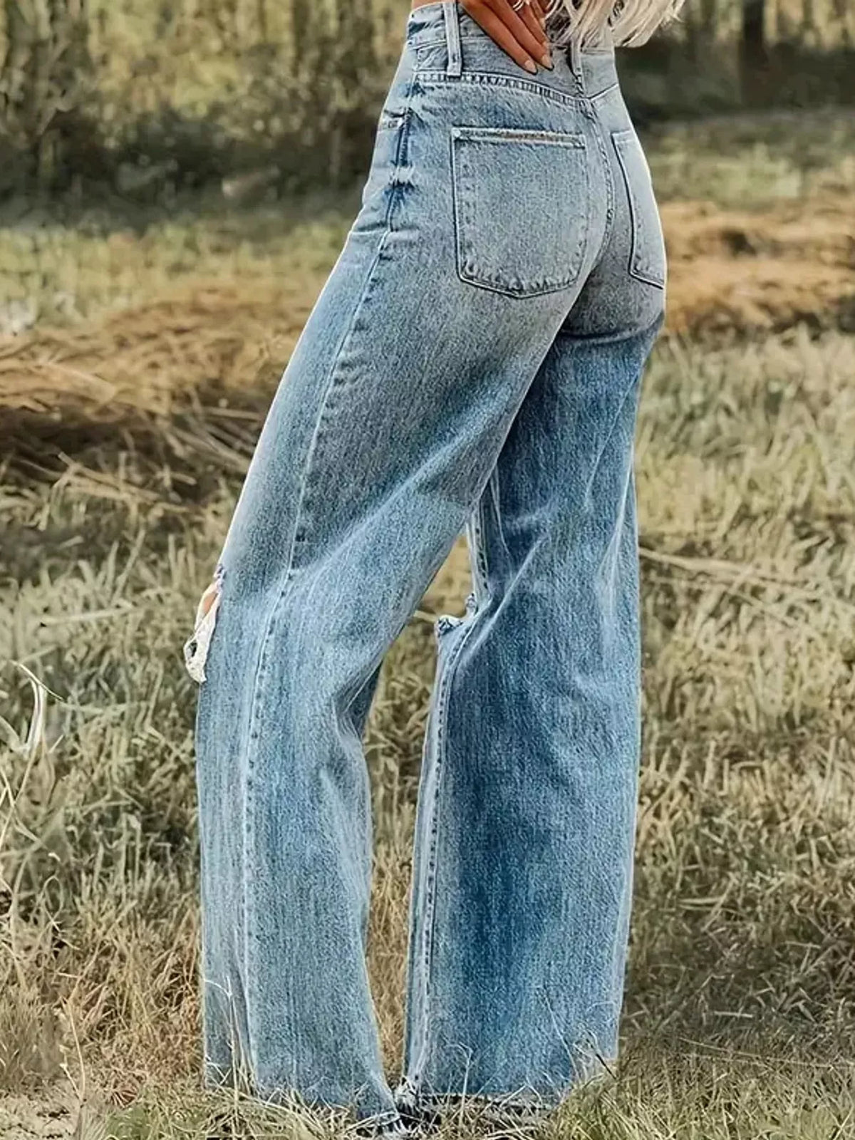 Rear angled view of light blue wide-leg jeans showing two back patch pockets