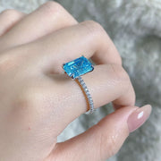 Close-up of the cushion-shaped center stone and surrounding halo on a silver ring.