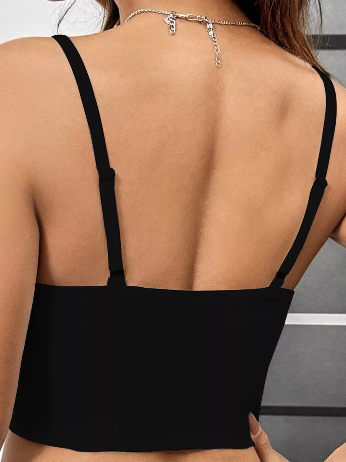 Back view of black crop cami with adjustable straps