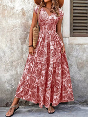 Green floral maxi dress with a high slit, shown on a model holding the skirt aside.