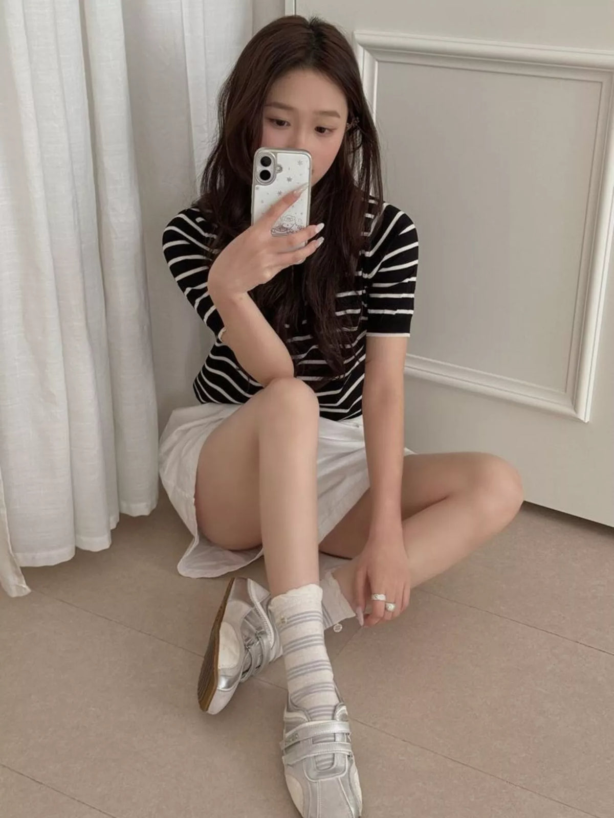 Mirror view of striped white mid-calf socks worn with sneakers