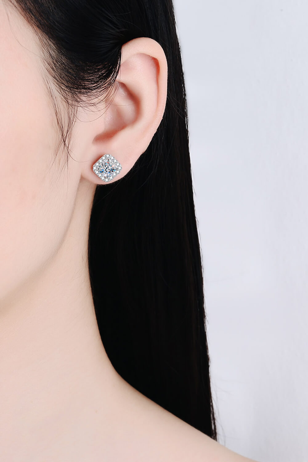 Square clear-stone cluster stud earring worn on an ear