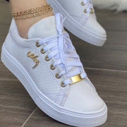 Black and brown lace-up sneakers shown on feet with white soles