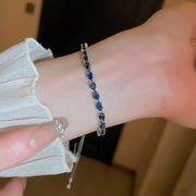 Blue-stone contrast bracelet worn on a wrist with its adjustable chain hanging below