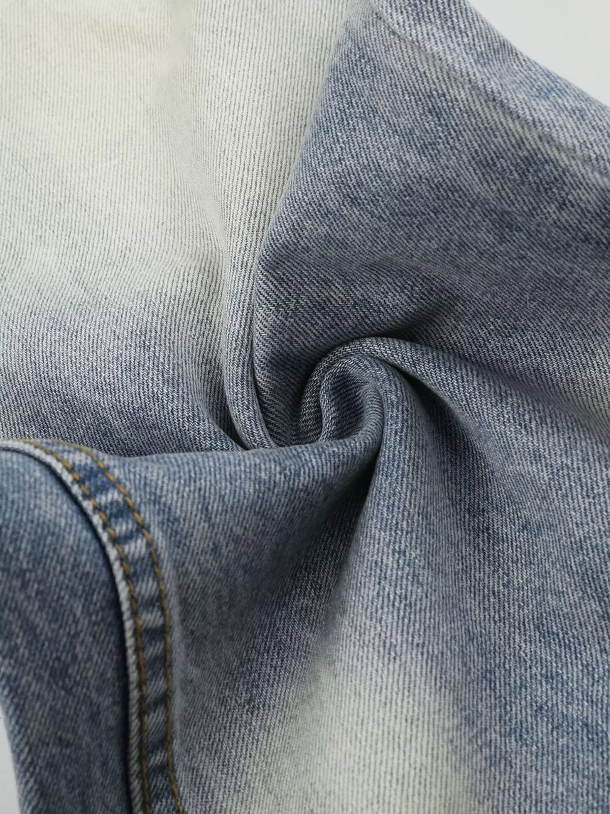 Close-up of faded denim fabric gathered into folds
