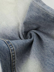 Close-up of faded denim fabric gathered into folds