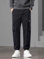 Front view of black cargo joggers with drawstring waist and flap thigh pockets.