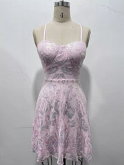 Pale lilac floral-sequin mini dress displayed on a dress form against a wall.