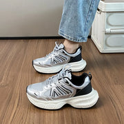 Silver and black lace-up platform sneakers worn with jeans