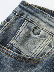 Close-up of the front coin pocket, belt loop and contrast stitching on vintage-wash jeans
