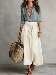 Gray button-down shirt paired with a cream midi skirt tied at the waist.