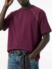 Model wearing burgundy T-shirt, angled front view