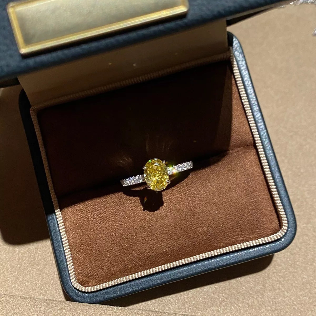 Copper oval zircon ring with polished yellow finish, side view