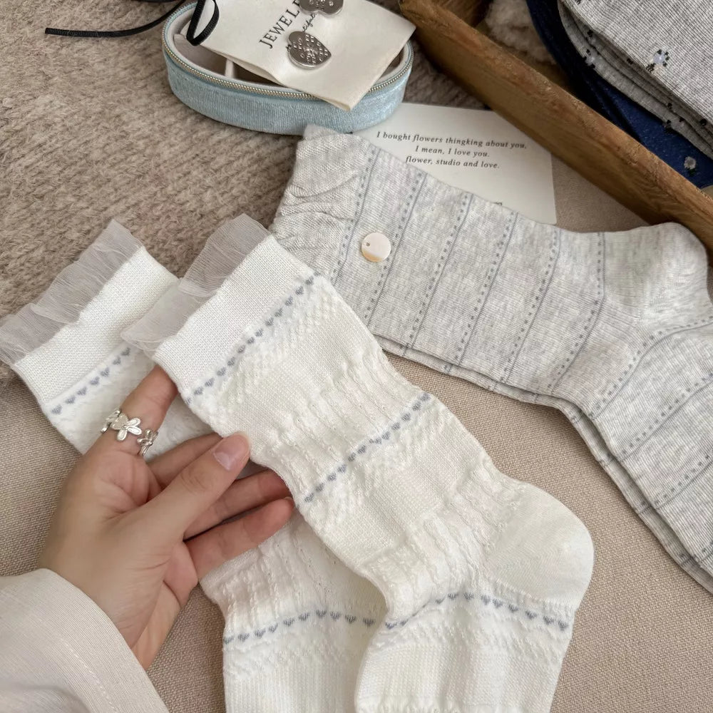 Close view of white knit socks held beside a patterned sock