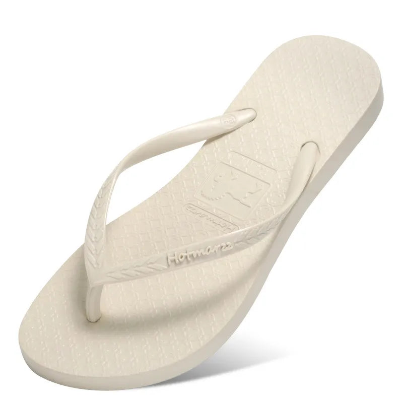 Ivory toe-post flip-flop with matching pale straps, angled view
