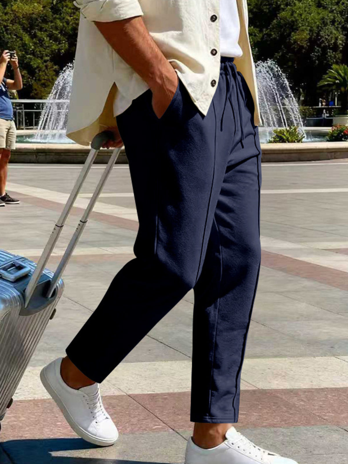 Side view of navy straight-leg pants with a hand in the pocket.