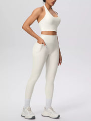 Model wearing white halter top and leggings with hand in pocket