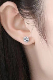 Round clear-stone stud earring worn on an ear with dark hair