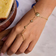 Gold-tone chain bracelet with sun charm worn on wrist