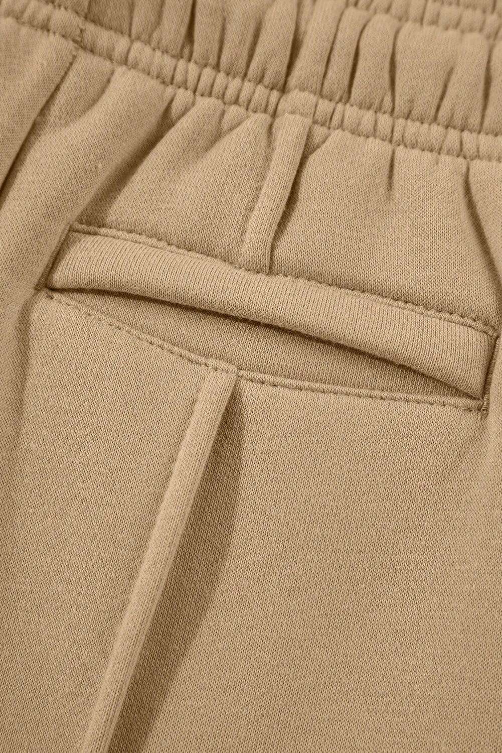 Close-up of a side pocket on tan wide-leg pants.